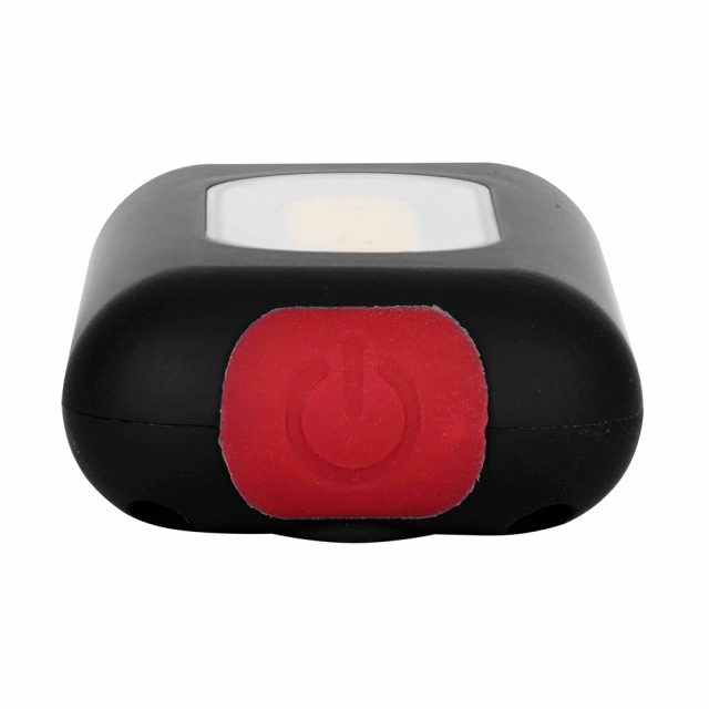 Close-up view of the red push button switch on the bottom of a black COB keychain light.