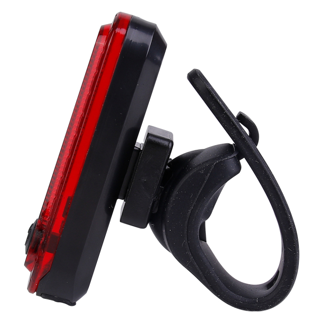 Side profile view of a red bicycle rear tail light with silicone bracket.