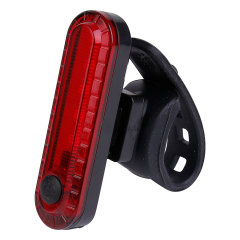 Angled view of a red LED bike rear light with a flexible silicone mounting strap.