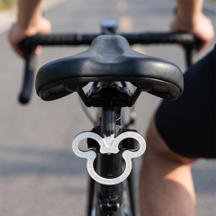 A cartoon head-shaped LED bike rear light mounted on a bicycle seatpost.