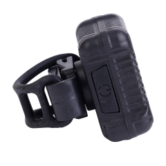 Side perspective of the COB LED bike light featuring a flexible silicone mounting strap and power button.