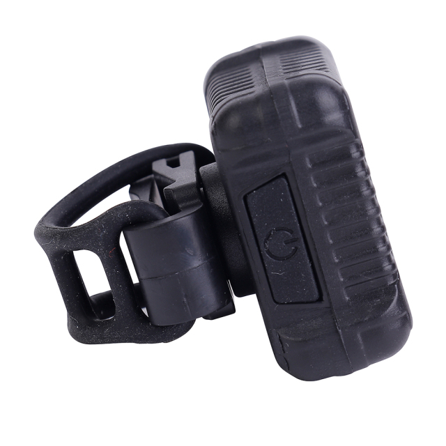 Side perspective of the COB LED bike light featuring a flexible silicone mounting strap and power button.