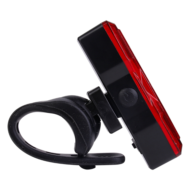 Side profile of a red bicycle tail light showing the power switch button.