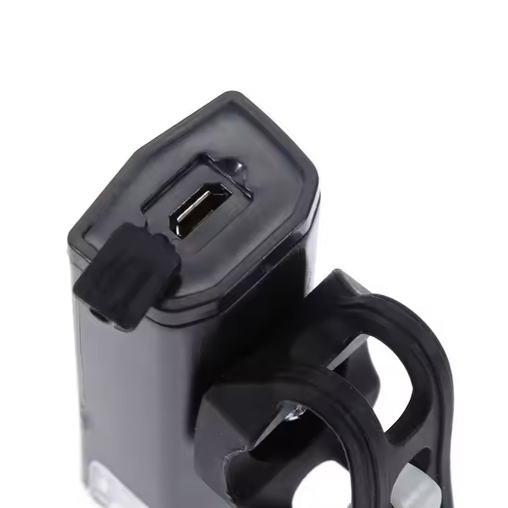 Close-up view of the Micro USB charging port with a protective rubber cover on the bike front light.