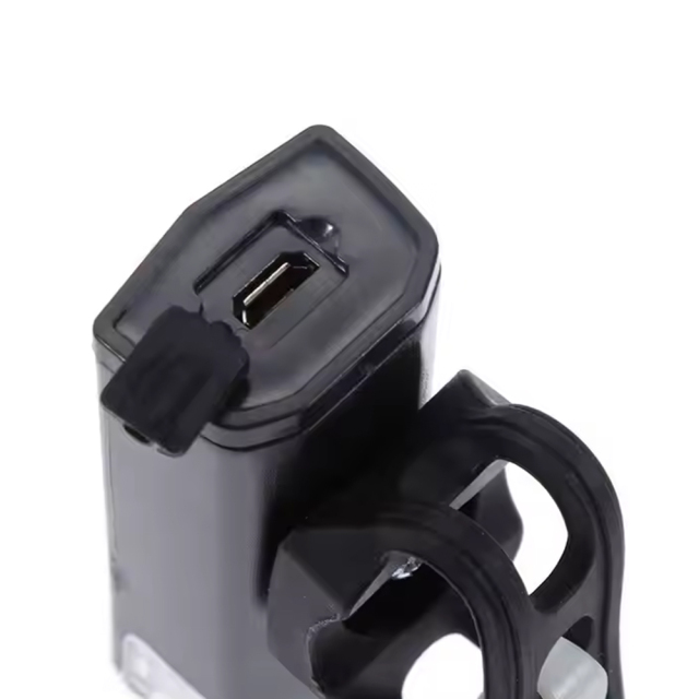 Close-up view of the Micro USB charging port with a protective rubber cover on the bike front light.