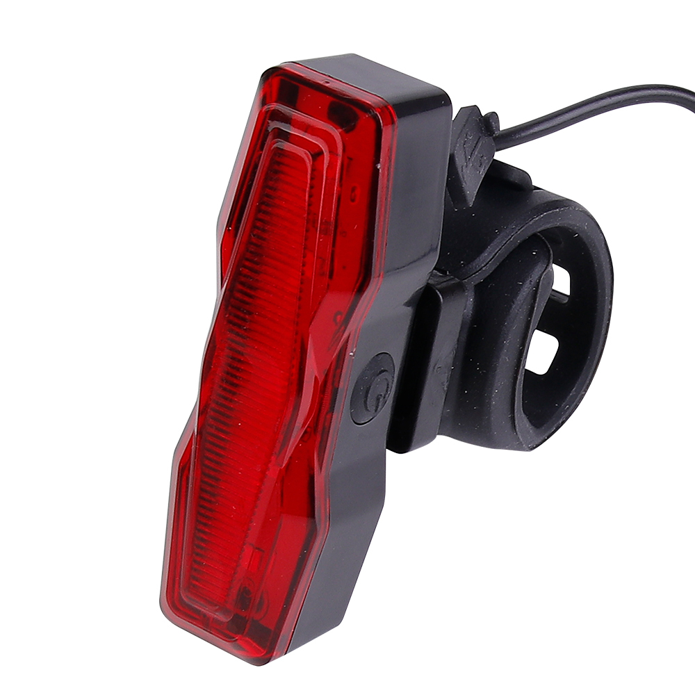 A USB charging cable plugged into the top port of a rechargeable LED bike tail light.