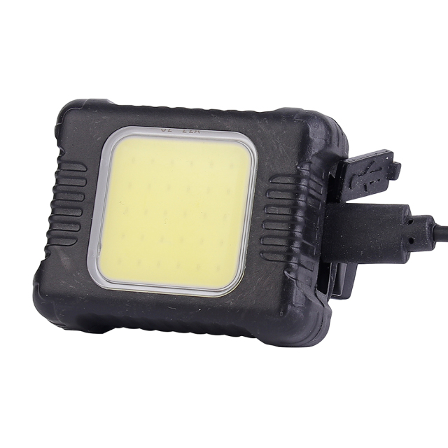 Close-up view of the square COB LED bike light plugged into a Type-C USB charging cable.