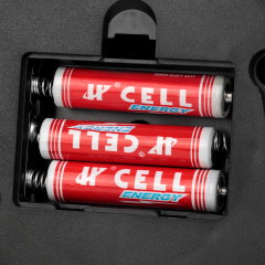 Close-up view of the open battery compartment loaded with three AAA batteries in the dummy security camera.
