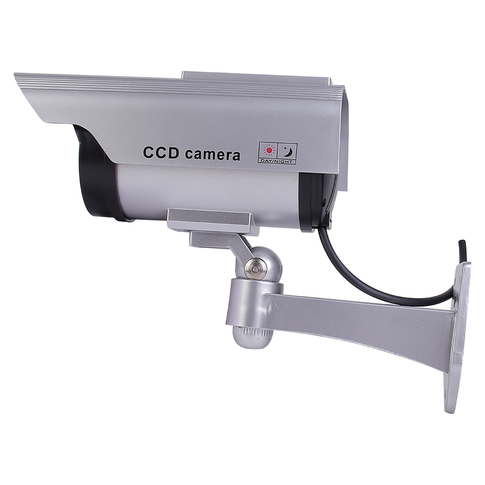 Side view of a silver dummy security camera showing the multi-axis wall bracket and connecting cable.