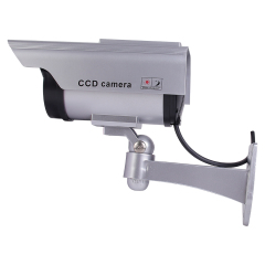 Side view of a silver dummy security camera showing the multi-axis wall bracket and connecting cable.