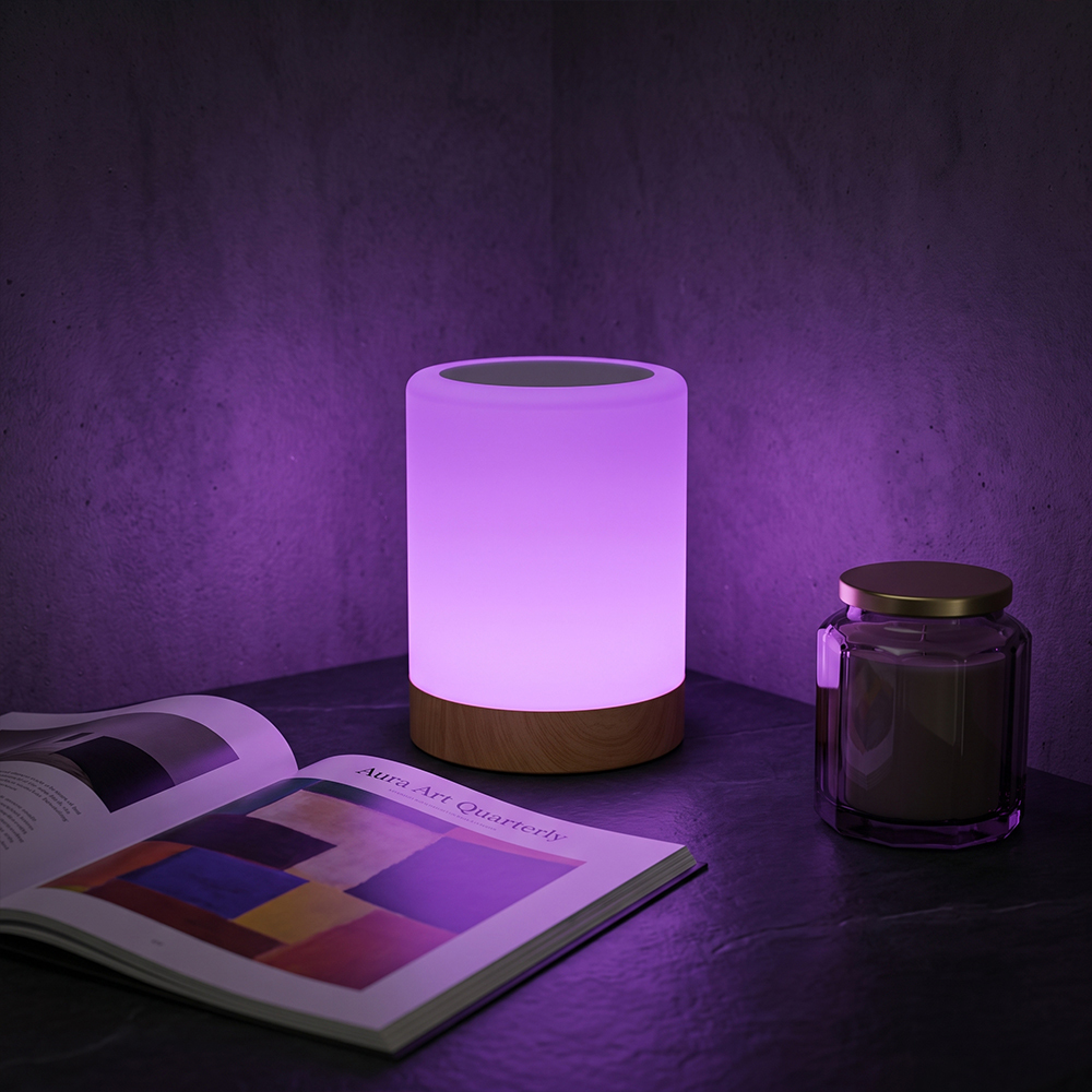 Cylindrical RGB touch lamp glowing in purple ambient light on a table with a magazine and jar.