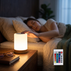 Warm cylindrical touch night light glowing on a bedside table next to a sleeping woman and remote control.