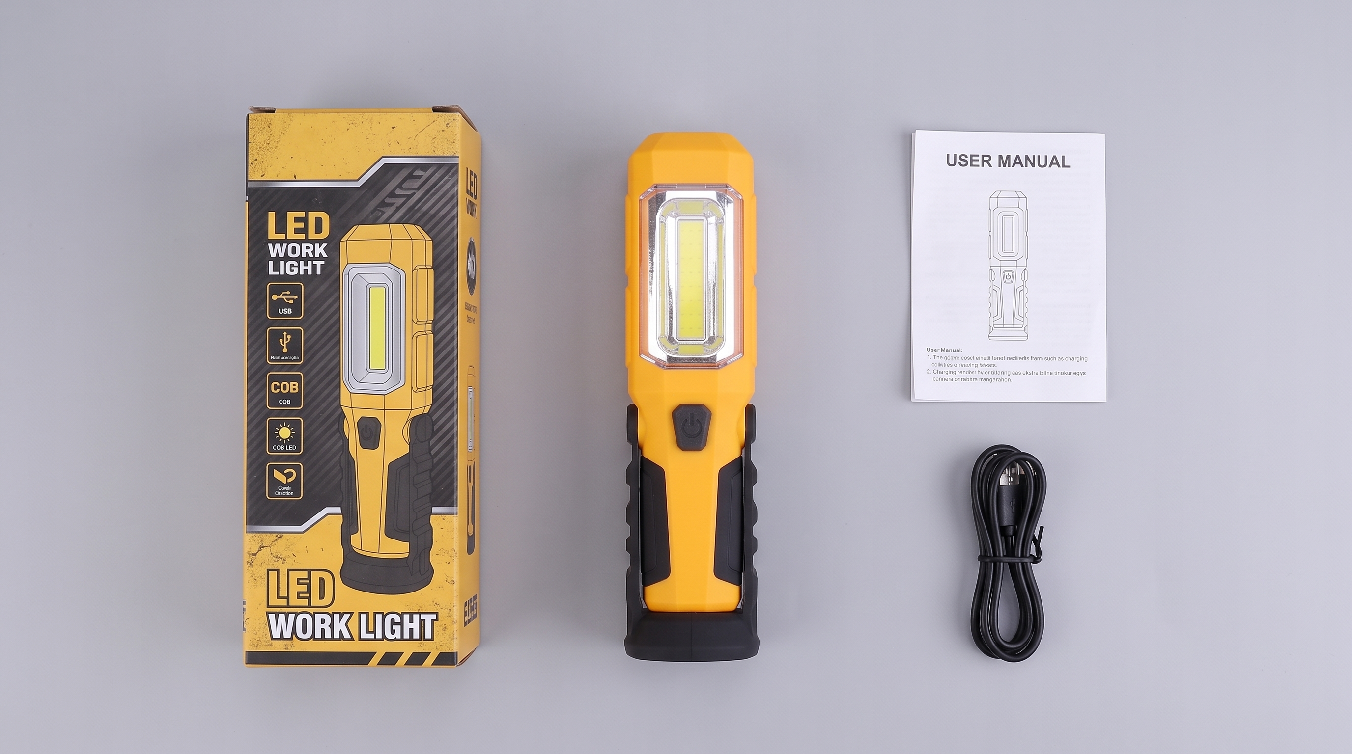 Yellow rechargeable COB LED work light shown with its retail packaging box, user manual, and USB charging cable on a neutral background.