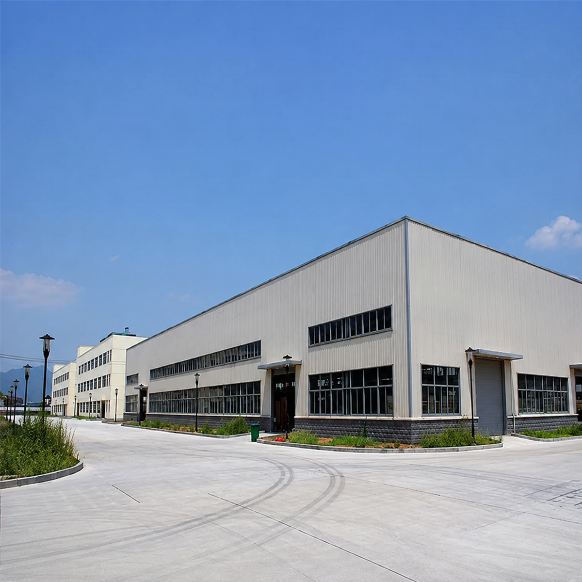 Exterior view of a completed steel structure factory building with metal cladding and large industrial entrances