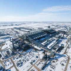 Aerial view of a large steel manufacturing complex covered in snow with multiple workshops and industrial facilities
