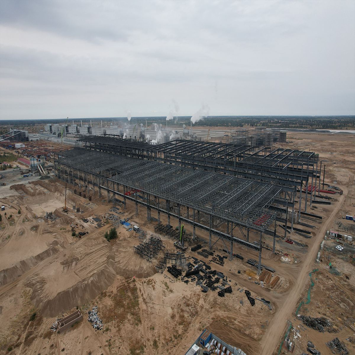 Aerial view of a heavy steel structure industrial building under construction at a large project site