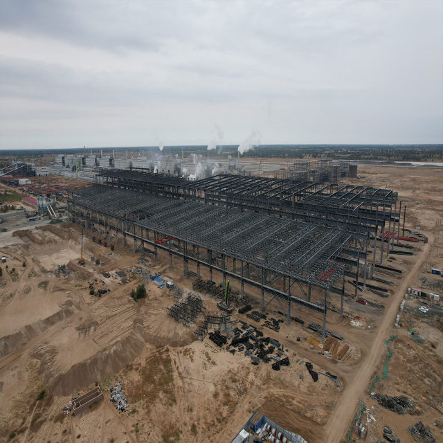 Aerial view of a heavy steel structure industrial building under construction at a large project site