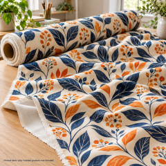 Mockup of custom decorative fabric with navy and orange botanical printing draped across a studio table