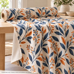 Mockup of custom printed curtain fabric with navy and orange botanical artwork draped over a studio table