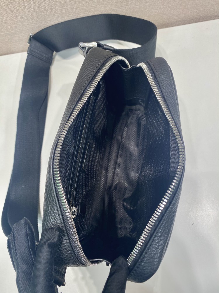 Prada's classic pebbled leather camera bag is the brand's signature unisex crossbody bag.