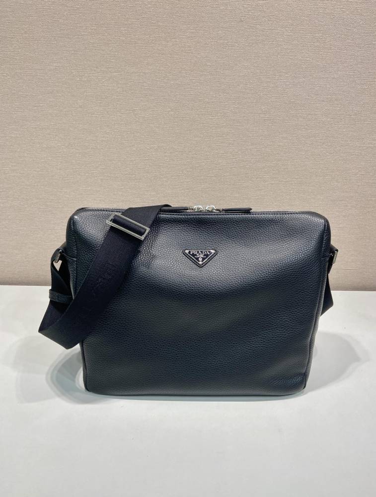 Prada's large messenger camera bag in pebbled calfskin is a signature unisex, spacious commuter style.