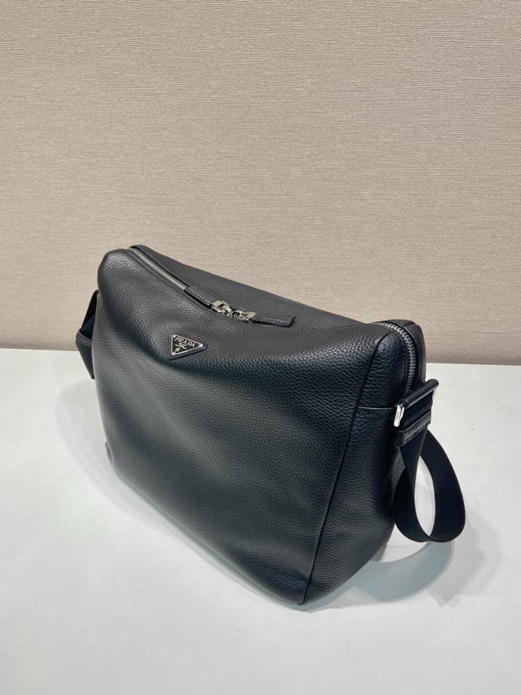 Prada's large messenger camera bag in pebbled calfskin is a signature unisex, spacious commuter style.