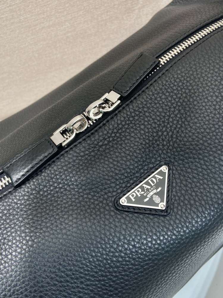 Prada's large messenger camera bag in pebbled calfskin is a signature unisex, spacious commuter style.