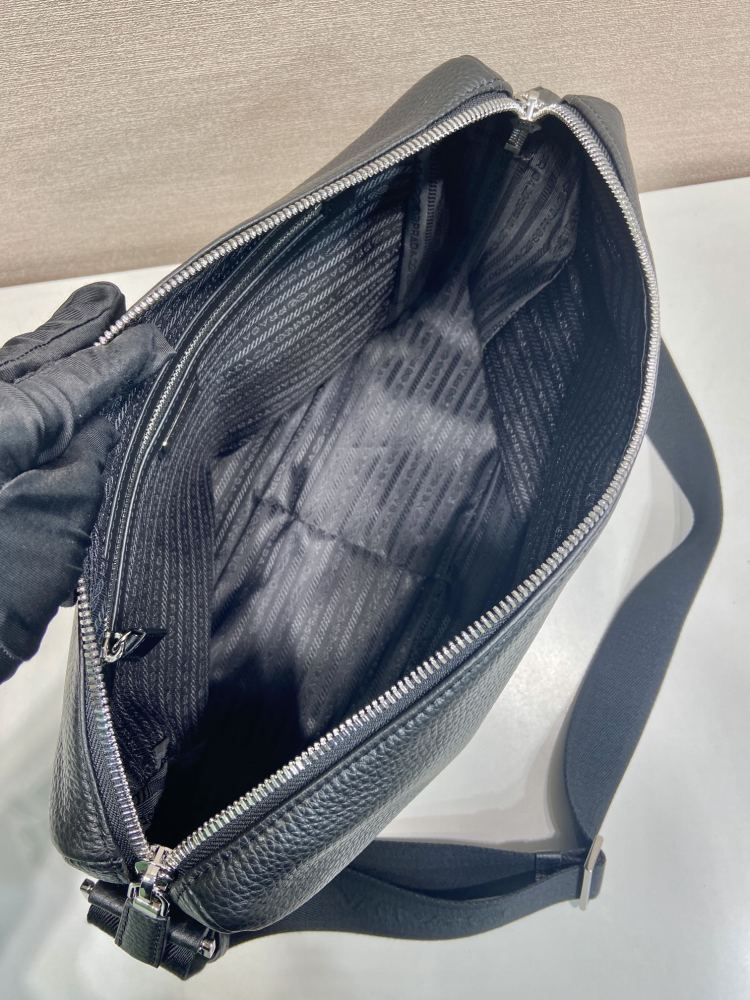 Prada's large messenger camera bag in pebbled calfskin is a signature unisex, spacious commuter style.