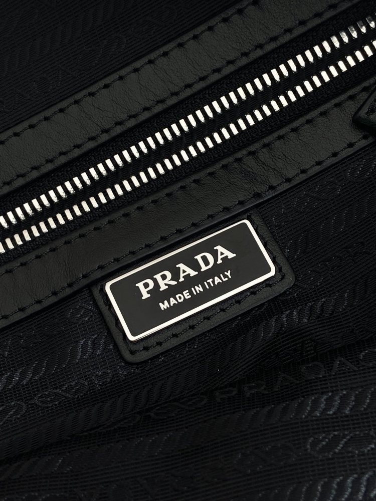Prada's large messenger camera bag in pebbled calfskin is a signature unisex, spacious commuter style.