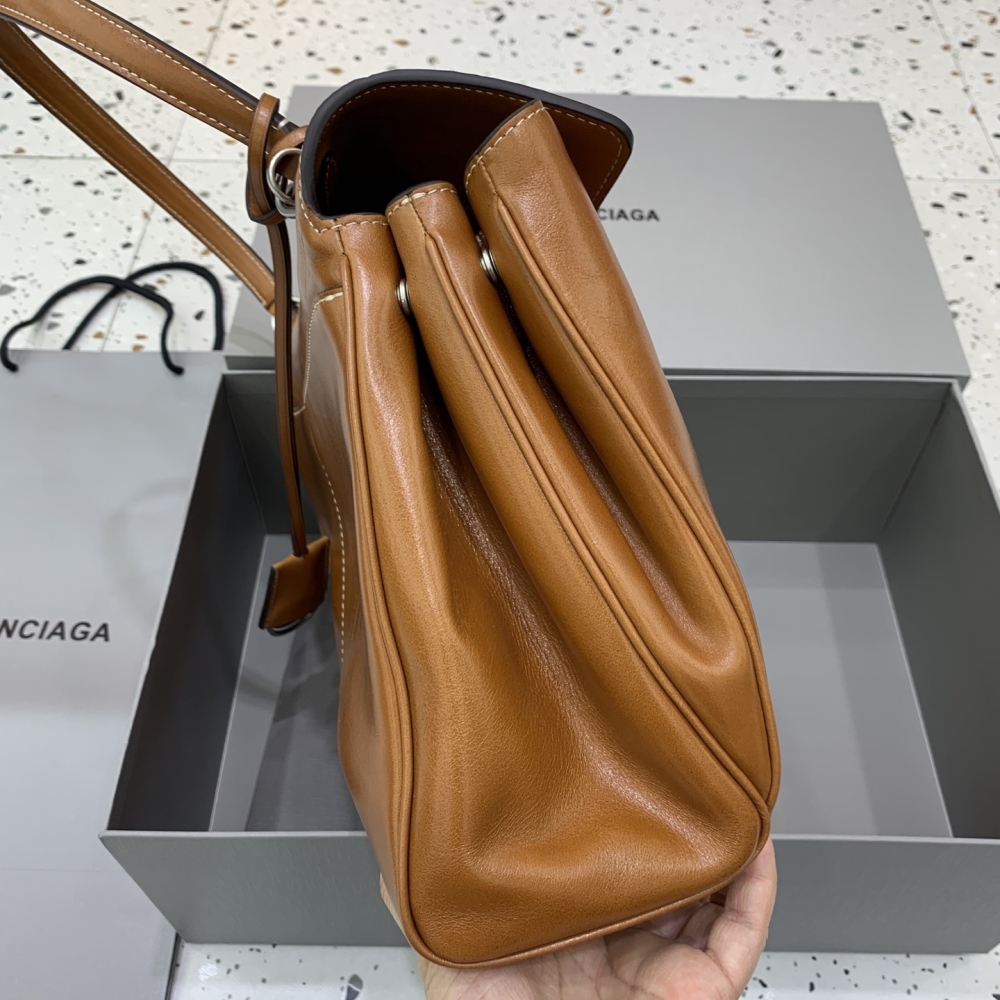 The Balenciaga Rodeo medium tote bag (caramel distressed color) is a minimalist commuter style that has been extremely popular in recent years.