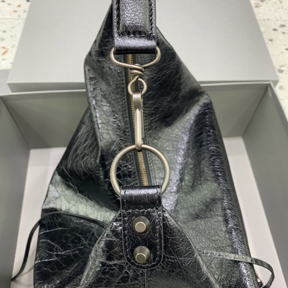 The Balenciaga Le City Hobo shoulder bag (black) is a modern derivative of the brand's classic motorcycle bag.