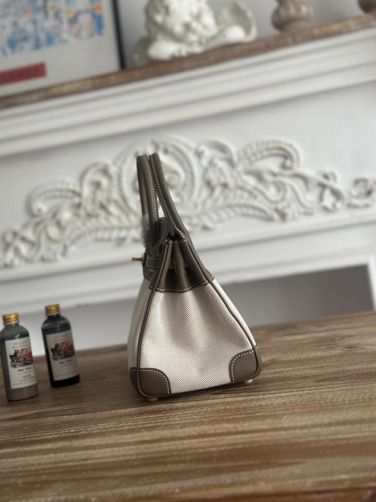 The Hermès Birkin-style canvas and leather tote bag, made of classic elephant grey leather and off-white canvas, is a popular lightweight commuter design in recent years.