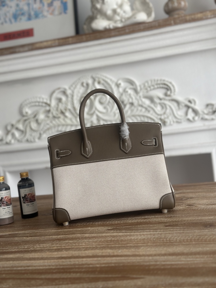 The Hermès Birkin-style canvas and leather tote bag, made of classic elephant grey leather and off-white canvas, is a popular lightweight commuter design in recent years.
