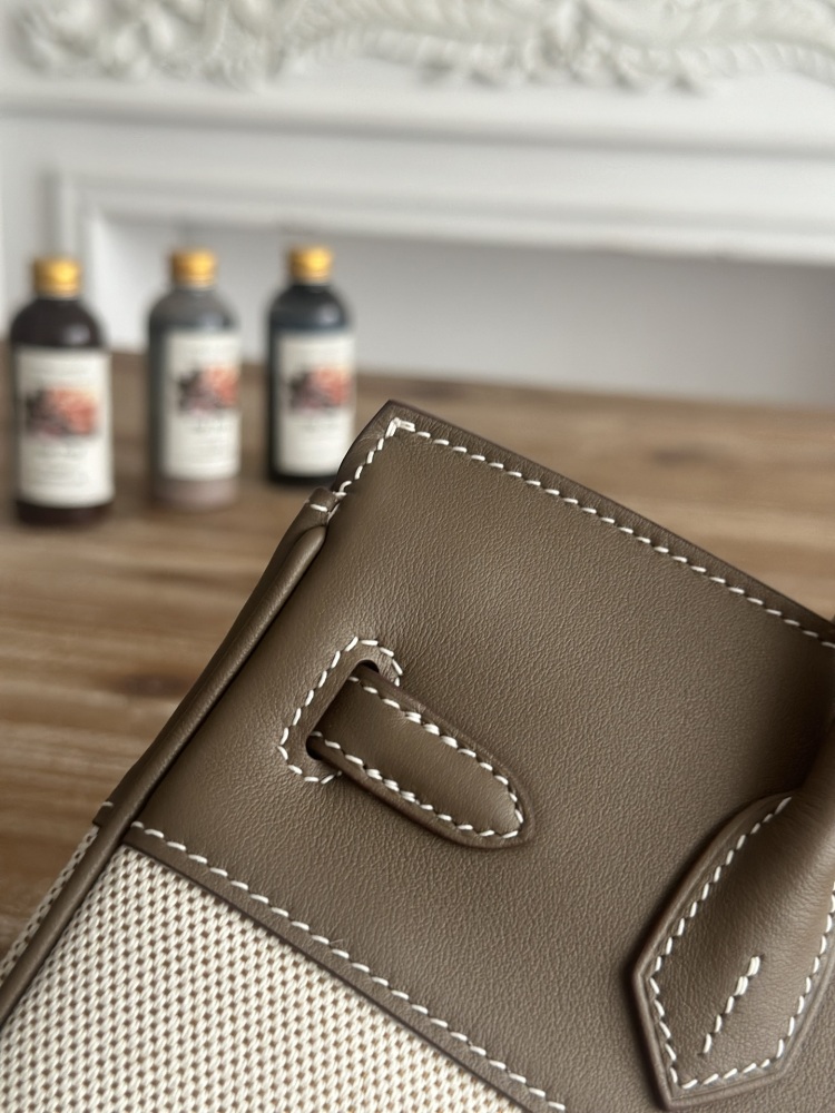 The Hermès Birkin-style canvas and leather tote bag, made of classic elephant grey leather and off-white canvas, is a popular lightweight commuter design in recent years.