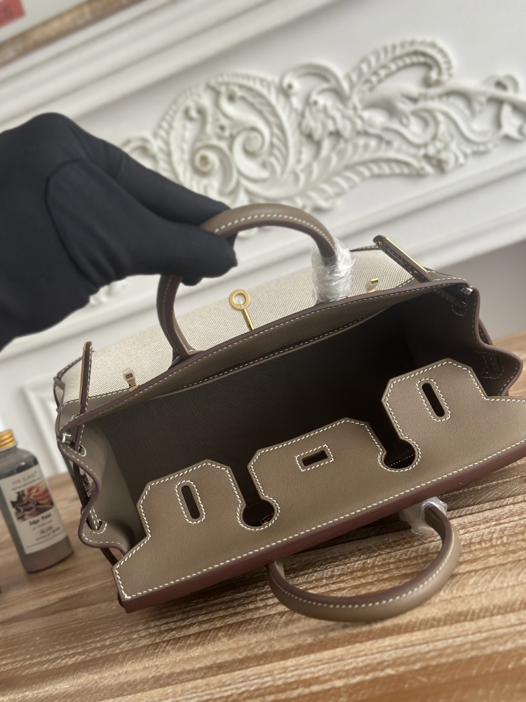 The Hermès Birkin-style canvas and leather tote bag, made of classic elephant grey leather and off-white canvas, is a popular lightweight commuter design in recent years.