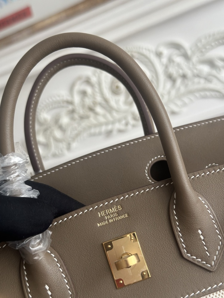 The Hermès Birkin-style canvas and leather tote bag, made of classic elephant grey leather and off-white canvas, is a popular lightweight commuter design in recent years.