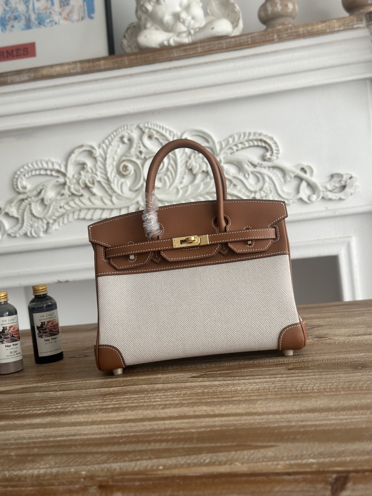 A Birkin-style bag in gold-brown leather and canvas, with an overall retro and versatile style.