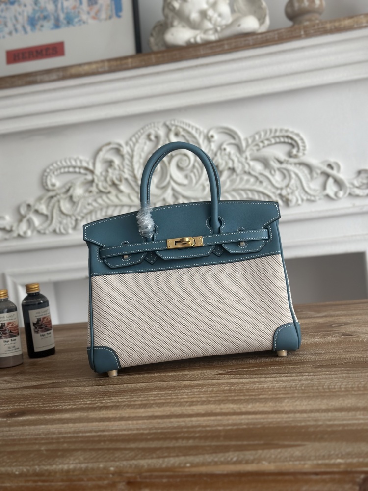 This Birkin-style tote bag in a dusty blue (denim blue) leather and canvas color scheme is a very popular lightweight commuter style in recent years.