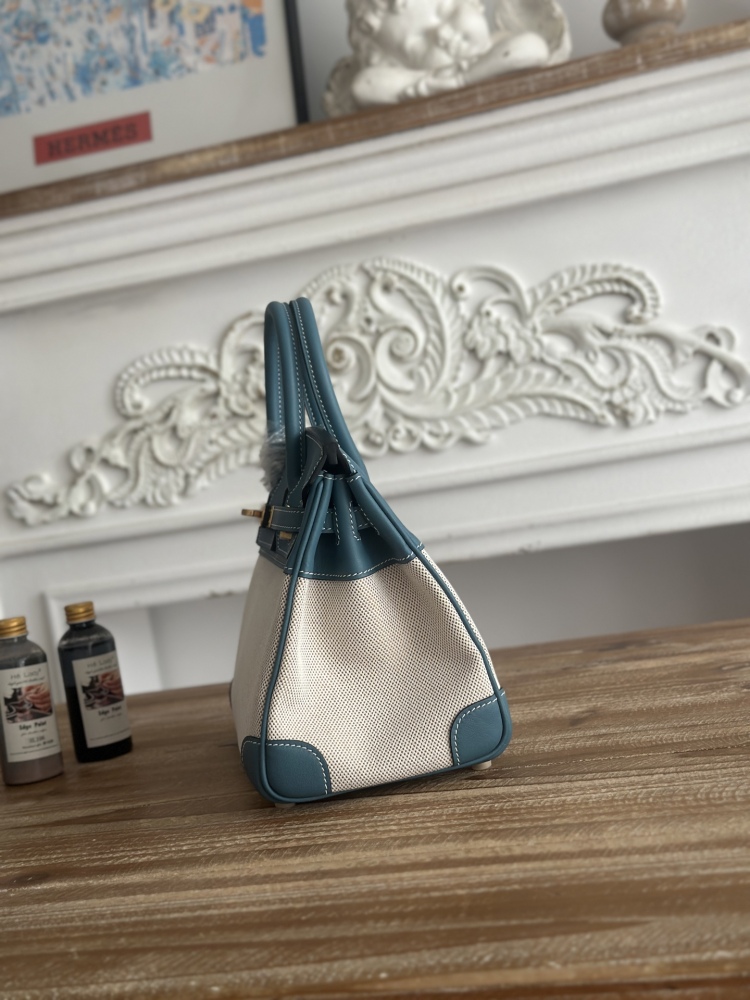 This Birkin-style tote bag in a dusty blue (denim blue) leather and canvas color scheme is a very popular lightweight commuter style in recent years.