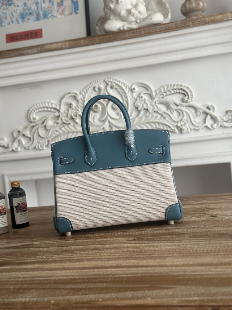 This Birkin-style tote bag in a dusty blue (denim blue) leather and canvas color scheme is a very popular lightweight commuter style in recent years.