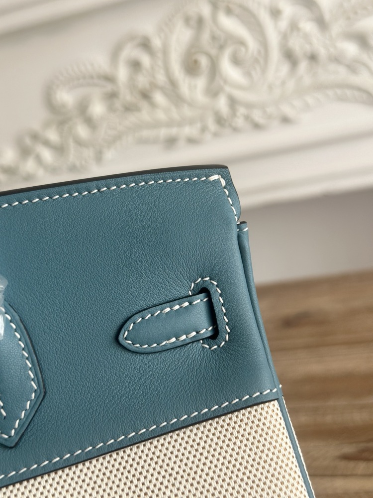 This Birkin-style tote bag in a dusty blue (denim blue) leather and canvas color scheme is a very popular lightweight commuter style in recent years.