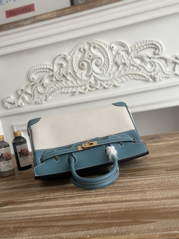 This Birkin-style tote bag in a dusty blue (denim blue) leather and canvas color scheme is a very popular lightweight commuter style in recent years.