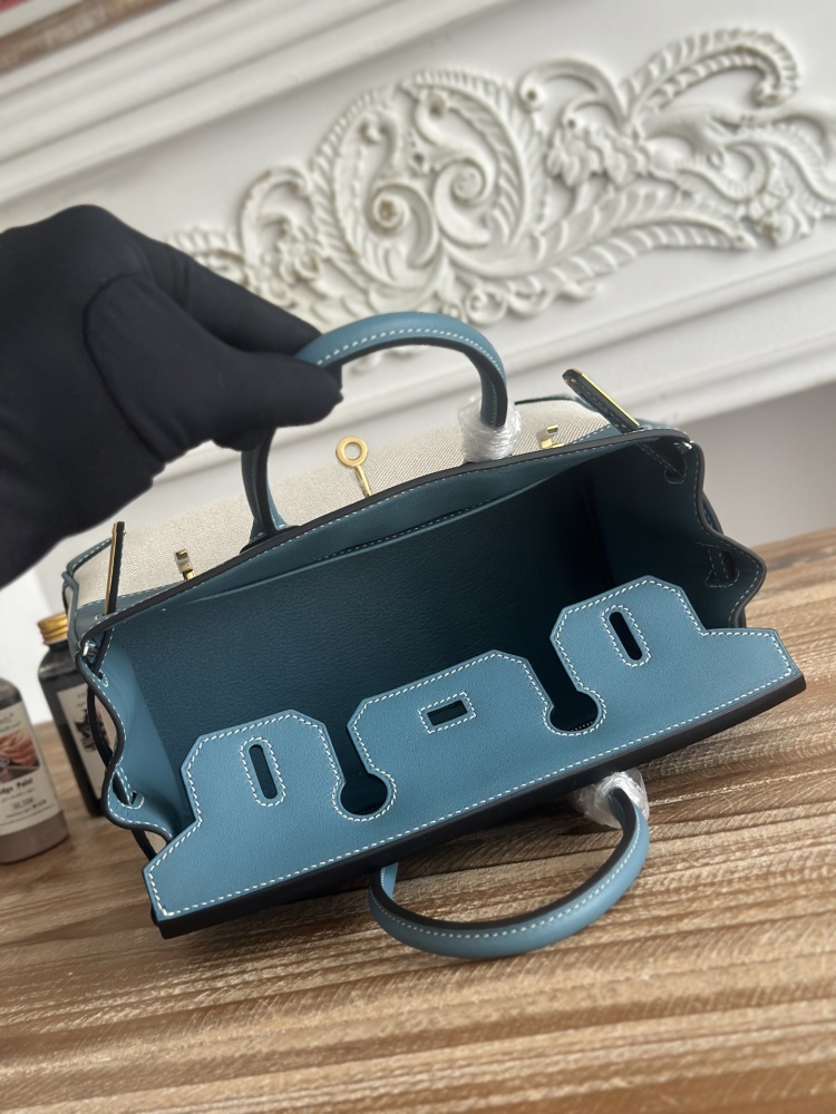 This Birkin-style tote bag in a dusty blue (denim blue) leather and canvas color scheme is a very popular lightweight commuter style in recent years.