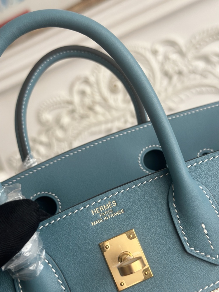 This Birkin-style tote bag in a dusty blue (denim blue) leather and canvas color scheme is a very popular lightweight commuter style in recent years.