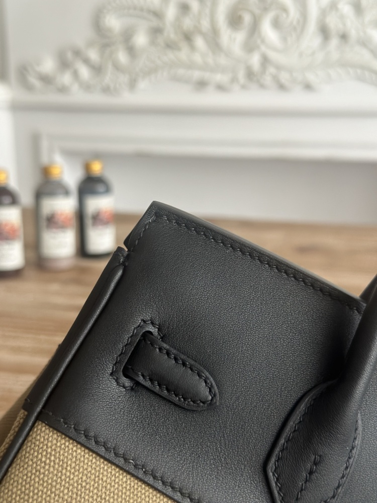 This Birkin-style tote bag features a military green canvas and black leather exterior, giving it a rugged yet retro look with a strong workwear feel.