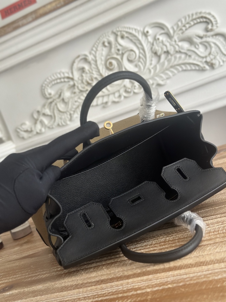 This Birkin-style tote bag features a military green canvas and black leather exterior, giving it a rugged yet retro look with a strong workwear feel.