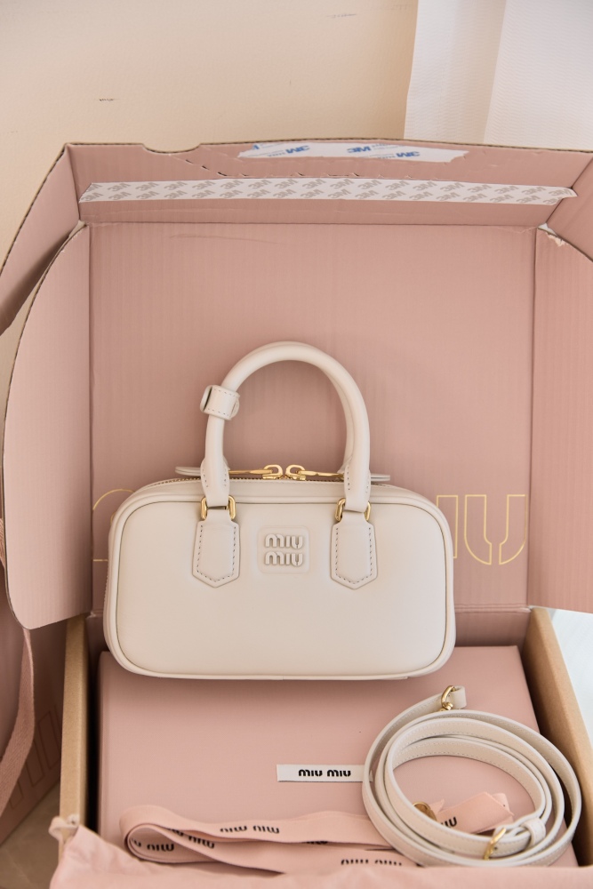 The Miu Miu Arcadie Small Leather Bowling Bag—often referred to as the "Mini Boston Bag" or "Pillow Bag"—is one of the brand's most popular styles in recent years, embodying a retro, sweet-girl aesthetic.