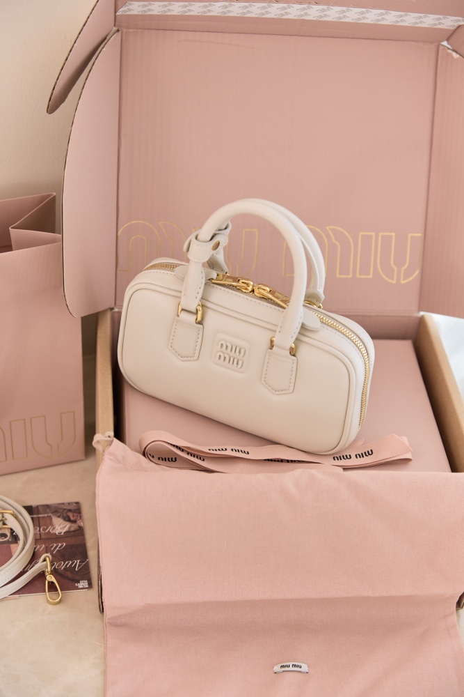 The Miu Miu Arcadie Small Leather Bowling Bag—often referred to as the "Mini Boston Bag" or "Pillow Bag"—is one of the brand's most popular styles in recent years, embodying a retro, sweet-girl aesthetic.