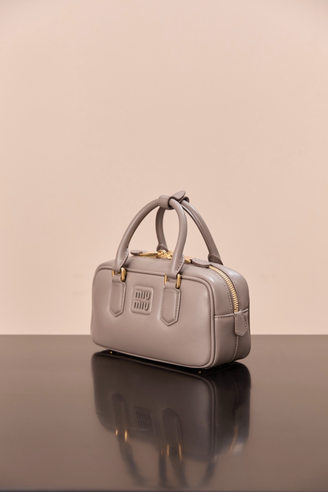The Miu Miu Arcadie Small Leather Bowling Bag (Elephant Grey) is one of the brand's popular retro Y2K-style handbags.
