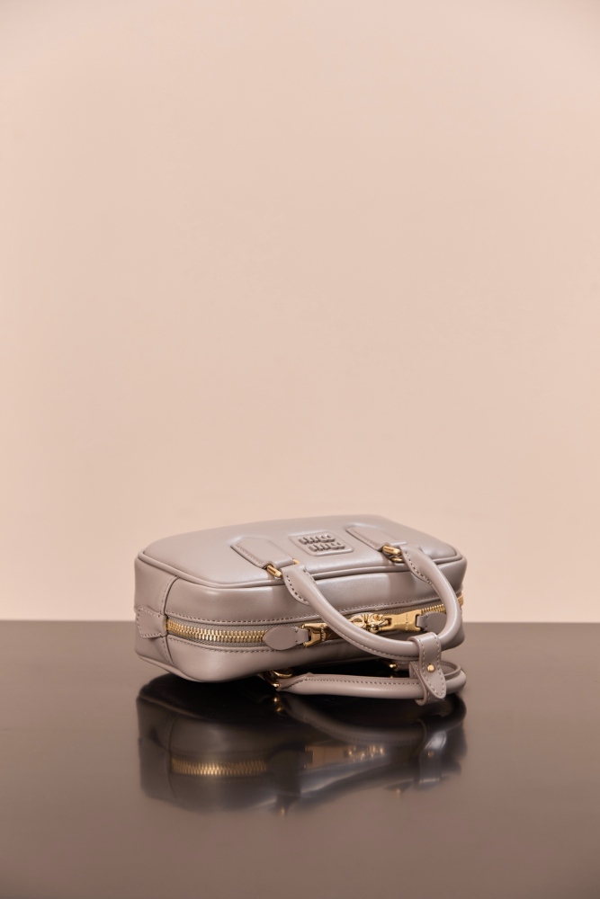 The Miu Miu Arcadie Small Leather Bowling Bag (Elephant Grey) is one of the brand's popular retro Y2K-style handbags.
